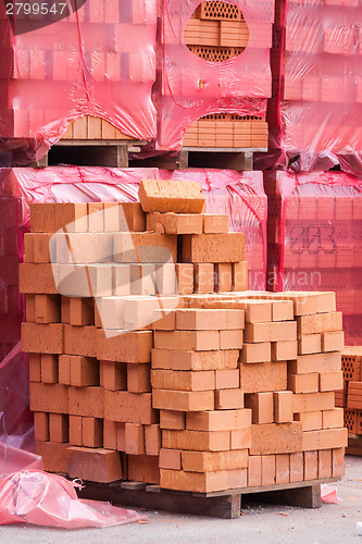 Image of Red clay bricks stacked on pallets