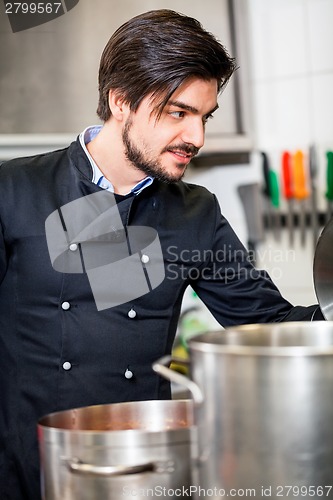 Image of Chef stirring a huge pot of stew or casserole