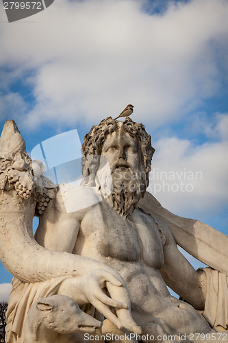 Image of Bird perched on an ancient stone statue