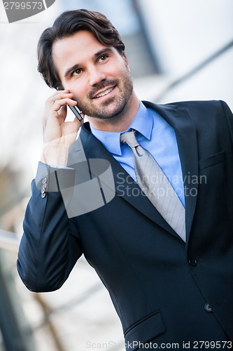 Image of Businessman listening to a call on his mobile