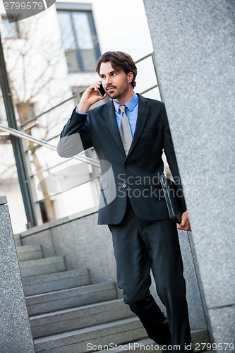 Image of Businessman listening to a call on his mobile