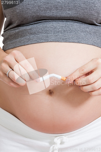 Image of Pregnant woman breaking a cigarette in two