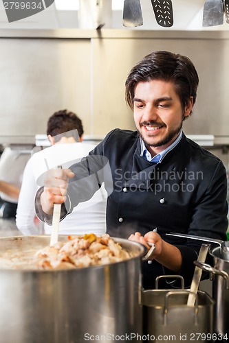 Image of Chef stirring a huge pot of stew or casserole