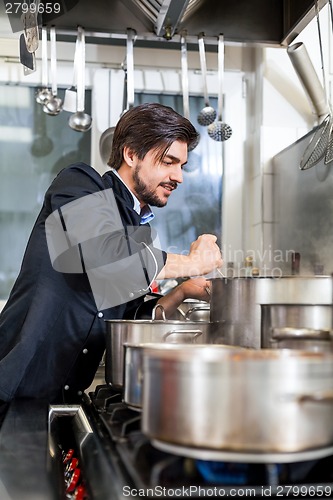 Image of Chef stirring a huge pot of stew or casserole