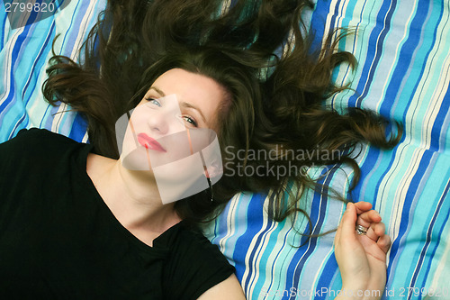 Image of Young woman resting on bed