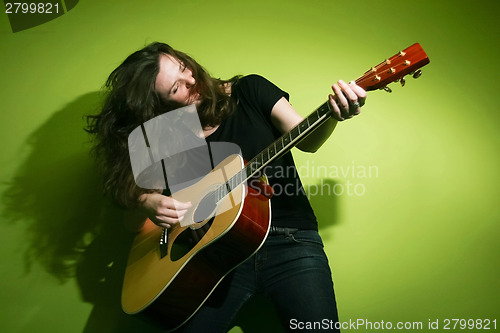 Image of Young woman playing guitar