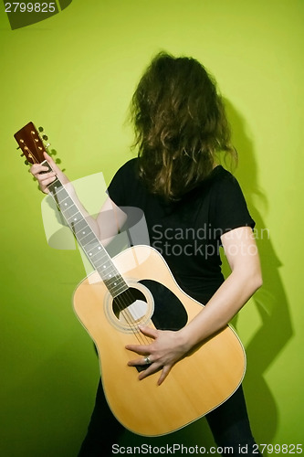 Image of Woman shaking hair with guitar