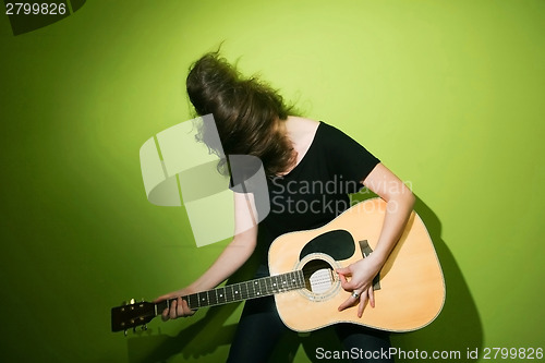 Image of Woman passionately playing guitar