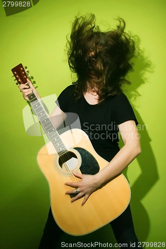 Image of Woman with guitar shaking hair