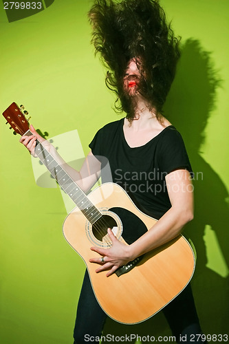 Image of Rock woman with guitar shaking hair