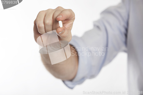 Image of Man in blue shirt takes pills