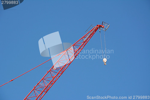 Image of Red crane boom against a blue sky