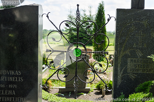 Image of brass ornament with shiny green stone in cemetery 