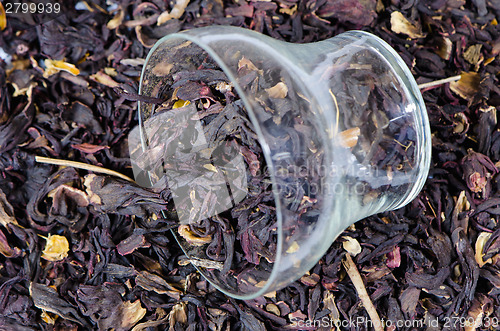 Image of black herbal tea pile background and cup 