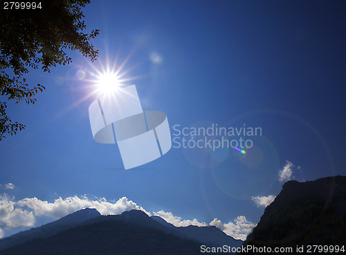Image of Shining sun on blue sky in the mountains
