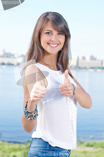 Image of Gorgeous young woman showing thumbs up