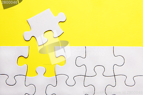 Image of White puzzle pieces on yellow background