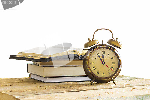 Image of Bible with clock on wood