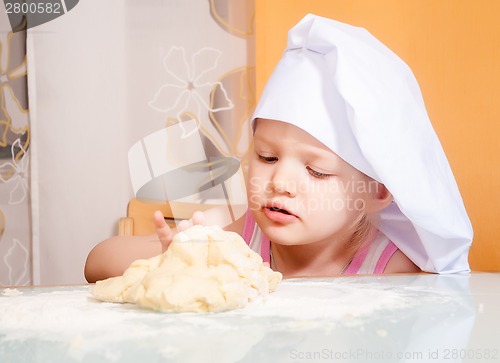 Image of baby girl in cook role molds from dough