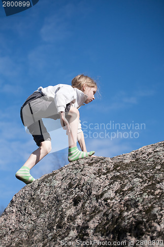 Image of little girl climbing the rock