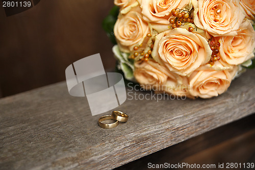 Image of Apricot color bridal bouquet with wedding rings