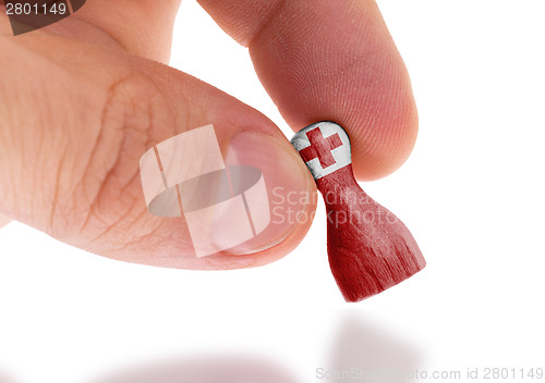 Image of Hand holding wooden pawn, flag painting, selective focus