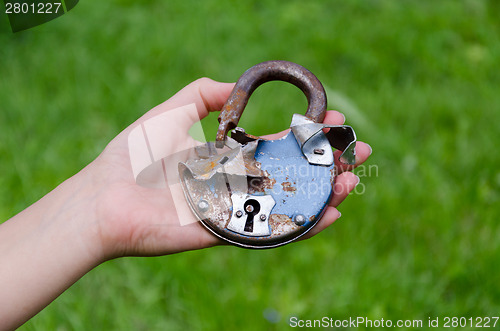 Image of old rusty broken door lock on man hand outdoor 