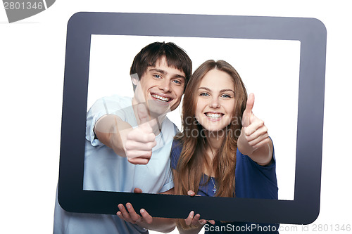 Image of Happy couple looking through tablet frame