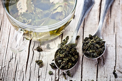 Image of cup of green tea and spoons 
