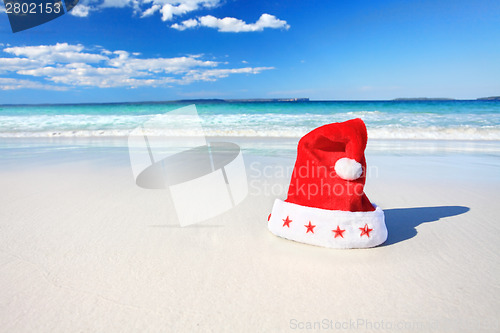 Image of Christmas Santa hat on sunny beach in Australia