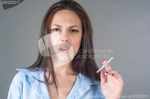 Image of Attractive young brunette woman with cigarette