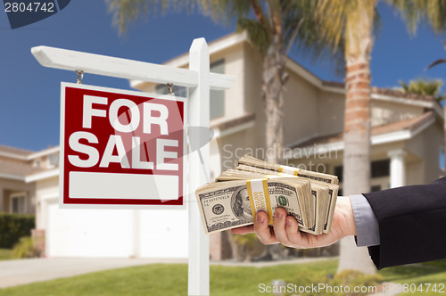 Image of Buyer Handing Over Cash for House with For Sale Sign