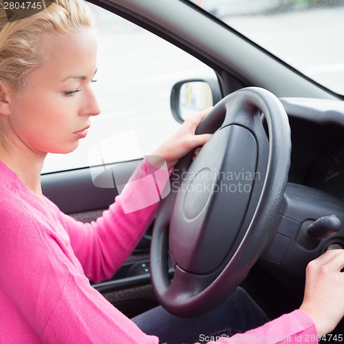 Image of Female car driver starting the engine.