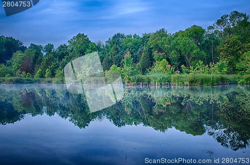 Image of sun rising over a foggy lake early morning