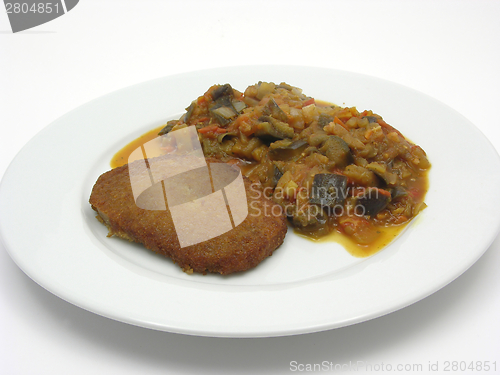 Image of Breaded bean curd cutlet with fried vegetable on a white plate