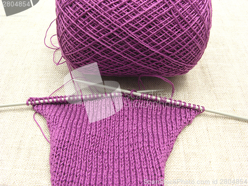 Image of Pink colored knitting on a  beige background