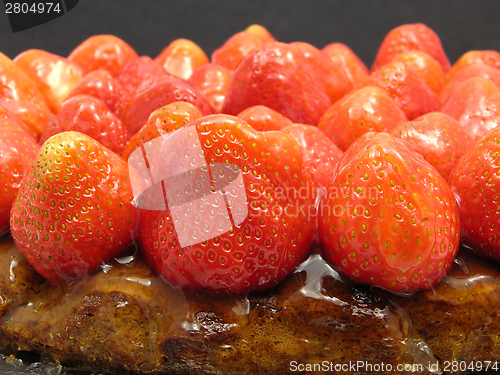 Image of Lateral close-up view of a strawberry cake on black background