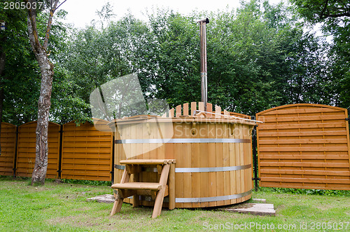 Image of rural wooden water hot tub with stairs garden yard 