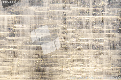 Image of Falling water stream against stone wall