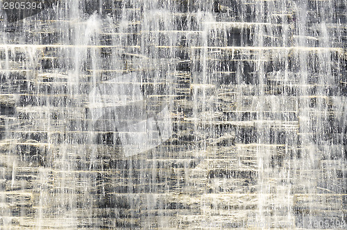 Image of Flowing water over dark grey stone wall