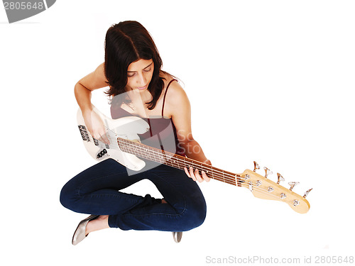 Image of Sitting woman playing guitar.