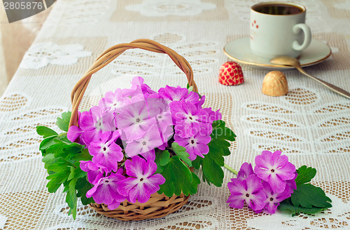 Image of Wattled basket with blossoming violets on a table.