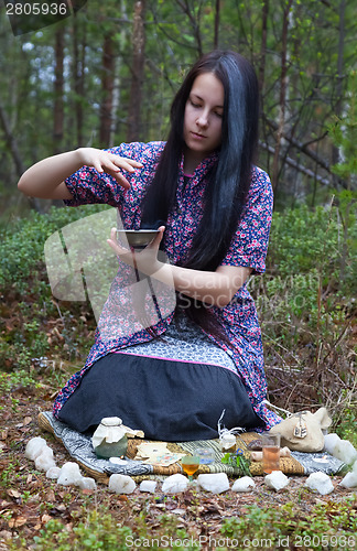 Image of Girl witch conjures in the woods 