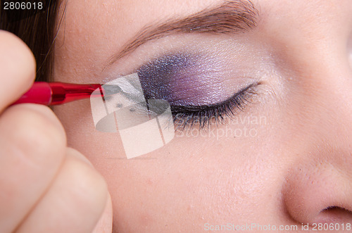 Image of Makeup artist draws arrows on the eyelids model