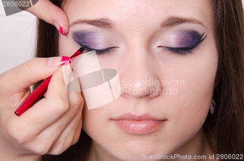 Image of Bright makeup. Makeup artist brings eyelashes