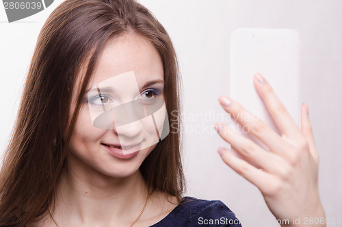 Image of Beautiful young girl looking in the mirror