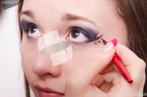 Image of Makeup artist paints a model's eyes