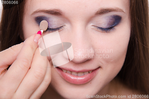 Image of Makeup artist is shaded eyelids beautiful girl