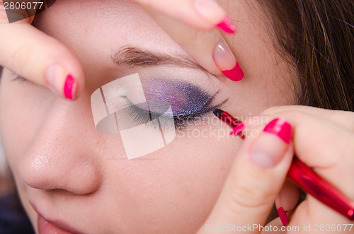 Image of Bright makeup. Makeup artist starts causing arrows