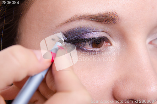 Image of Girl draw arrows in the makeup